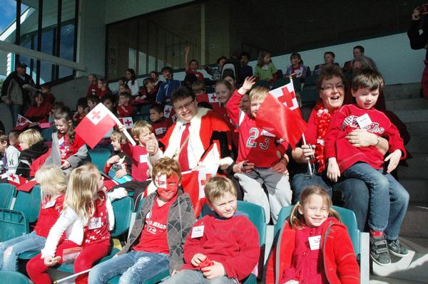 Mayor Ray Wallace up in the stands at the Hutt Rec with a group of children from Normandale School who came dressed in red and white and waving Tongan flags.